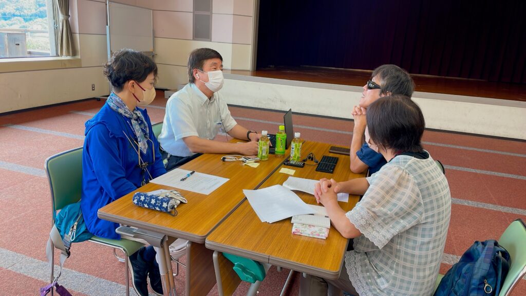 相談会の一場面。サポーターとユーザーが対面して座り、ユーザーの質問にサポーターが答えている。